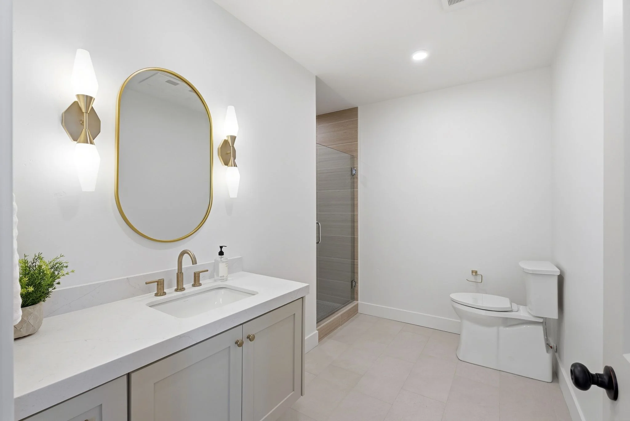 Secondary bath detail with vanity and brass fixtures